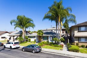 Downey multi-family for rent - A row of houses with cars parked in front.