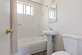 Los Angeles multi-family for rent - A white bathroom with a sink, toilet, and bathtub.