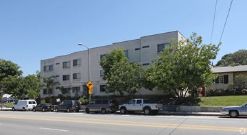 Los Angeles multi-family for rent - A street view of a building with cars parked in front.