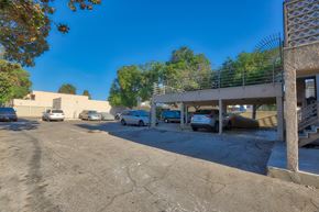 South El Monte multi-family for rent - A parking lot with several cars and a building in the background.