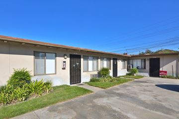 Norwalk multi-family for rent - A building with a black door and a sign on the wall.