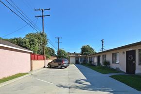 Norwalk multi-family for rent - A car is parked on a street in front of a building.