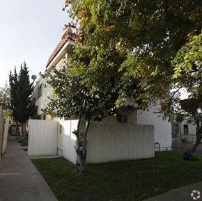 Van Nuys multi-family for rent - A tree with green leaves is in front of a white house.