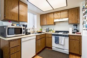 Lawndale multi-family for rent - A kitchen with wooden cabinets and a white dishwasher.
