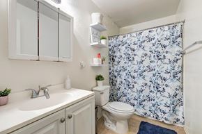 Lawndale multi-family for rent - A small bathroom with a sink, toilet, and shower curtain.