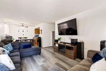 Lawndale multi-family for rent - A living room with a grey couch and a television on a cabinet.