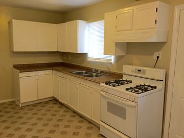 Los Angeles apartment for rent - A kitchen with white cabinets and a white stove top oven.