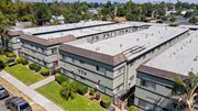 Pomona apartment for rent - A large, multi-story building with a flat roof and a parking lot in front.