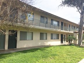 Montebello multi-family for rent - A building with a balcony and a tree in front of it.