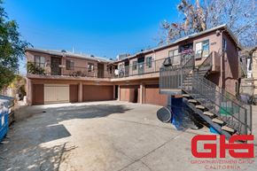 Los Angeles multi-family for rent - A sunny day at a multi-story apartment complex with a clear blue sky.
