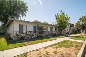 La Puente multi-family for rent - A row of houses with a stone wall in front of the first one.