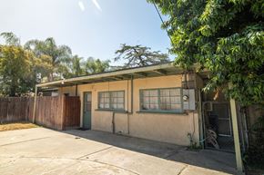 La Puente multi-family for rent - A house with a green door and a brown fence.