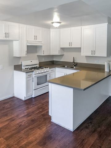 Monrovia multi-family for rent - A kitchen with white cabinets and a wooden floor.