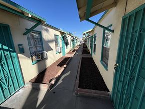 Maywood multi-family for rent - A row of houses with teal doors and windows.