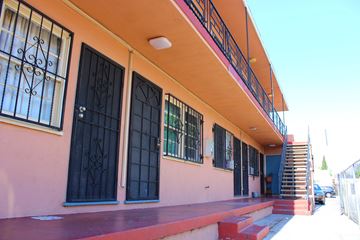 Huntington Park multi-family for rent - A building with a red staircase leading to a blue door.