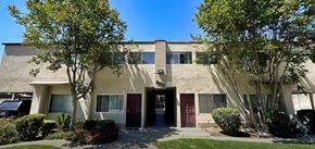 Los Angeles multi-family for rent - A building with a red door and windows surrounded by trees.