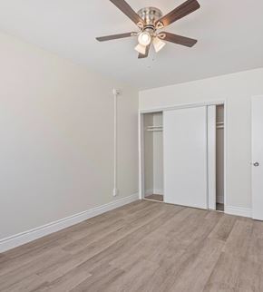 Los Angeles multi-family for rent - A room with a ceiling fan and light fixture, a door, and a window.