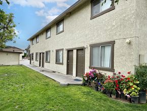 Fontana multi-family for rent - A building with a row of windows and flower pots in front.