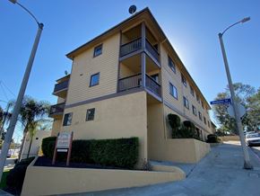 Harbor City multi-family for rent - A yellow building with a balcony on the second floor.