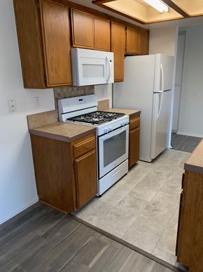 Harbor City multi-family for rent - A kitchen with a stove, microwave, and refrigerator.