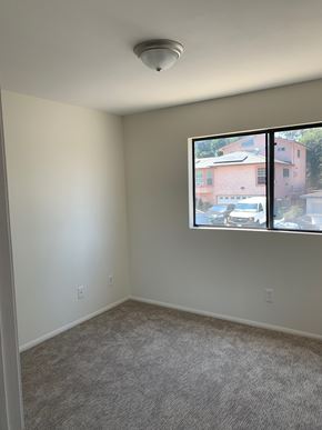 Harbor City multi-family for rent - A room with a window showing a view of houses outside.