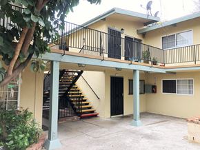 Lynwood multi-family for rent - A yellow house with a black door and a staircase.
