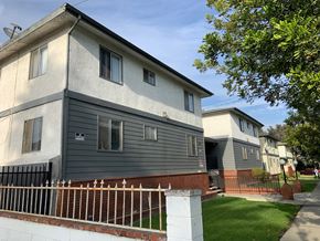 Inglewood multi-family for rent - A grey house with a white fence in front.