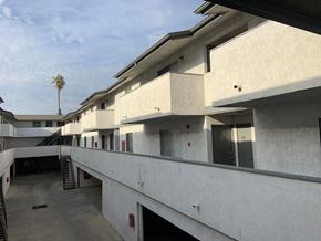 Inglewood multi-family for rent - A concrete building with a palm tree in the background.