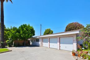 Downey multi-family for rent - A two-car garage with a white exterior and a brown roof.