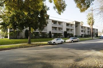 Ontario multi-family for rent - Apartment building with cars parked in front.
