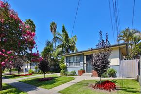 Downey apartment for rent - A house with a white fence and a tree in front of it.