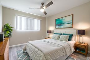 Rowland Heights multi-family for rent - A bedroom with a large bed, a ceiling fan, and a painting on the wall.