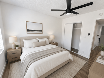 Gardena multi-family for rent - A bedroom with a large bed, a ceiling fan, and a small nightstand with a lamp.
