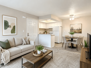 Hemet multi-family for rent - A living room with a couch, coffee table, and a dining area in the background.