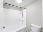 Hemet multi-family for rent - A white bathroom with a tub, toilet, and shower.