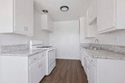 Bellflower multi-family for rent - A kitchen with white cabinets and granite countertops.