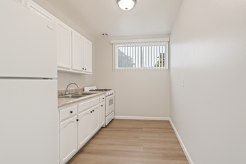 Hawthorne multi-family for rent - A kitchen with white cabinets and a window.