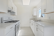 Sun Valley multi-family for rent - A white kitchen with a stove, sink, and cabinets.