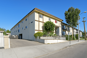 Sun Valley multi-family for rent - A building with a white facade and a yellow roof is surrounded by a fence and has a tree in front of it.