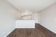Pomona multi-family for rent - A kitchen with white cabinets and a wooden floor.