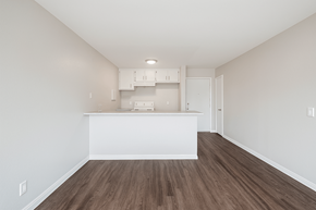 Pomona multi-family for rent - A kitchen with white cabinets and a wooden floor.
