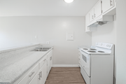 Pomona multi-family for rent - A kitchen with a stove, sink, and cabinets.