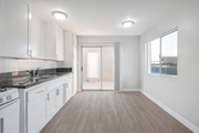 Rialto multi-family for rent - A kitchen with white cabinets and a black countertop.