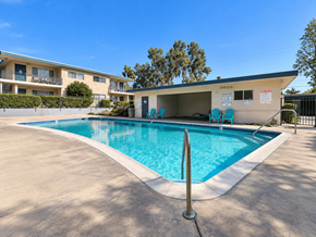 Claremont multi-family for rent - A swimming pool in front of a building with a blue sky in the background.