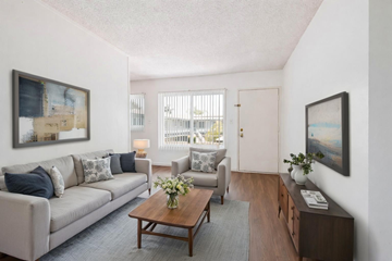 Bellflower multi-family for rent - A living room with a grey couch, a coffee table, and a painting on the wall.