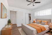 Bellflower multi-family for rent - A bedroom with a bed, a ceiling fan, and a wooden nightstand.