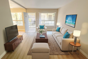 Lynwood multi-family for rent - A living room with a white couch, a coffee table, and a television.