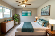 Lynwood multi-family for rent - A bedroom with a bed, dresser, and ceiling fan.