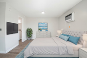 Pomona multi-family for rent - A bedroom with a bed, nightstand, and a painting on the wall.