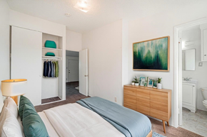 Downey multi-family for rent - A bedroom with a bed, a dresser, and a painting on the wall.